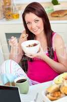 Attractive caucasian woman having breakfast smiling at the camer