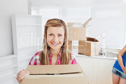 Bright woman carrying boxes at home