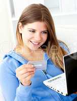 Happy woman with a credit card and a laptop