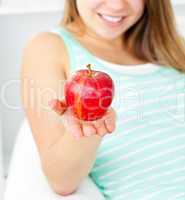 Cute young woman holding an apple in her hand