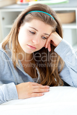 Dejected young woman sitting at the table in the kitchen