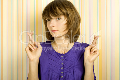 Young woman with fingers crossed