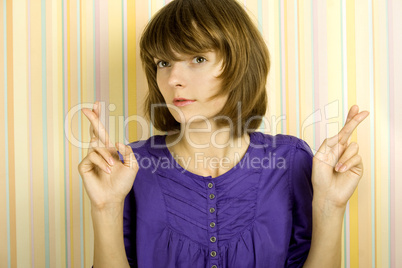 Young woman with fingers crossed