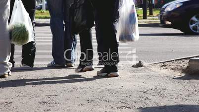 People walking on zebra crossing with bag