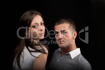 Woman and man posing on a black background