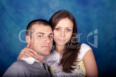 Woman and man posing together on a blue background