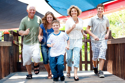 Family of five running on the wooden bridge