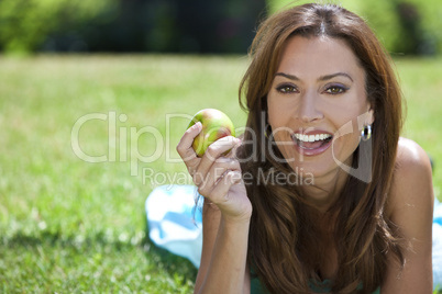 Beautiful Woman Outside Eating An Apple and Smiling