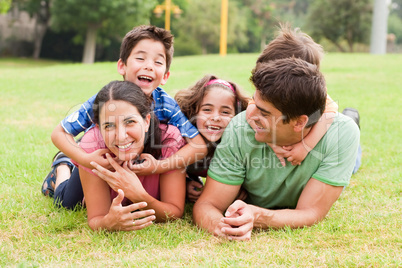 Playful family lying outdoors and smiling