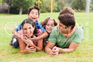 Playful family lying outdoors and smiling