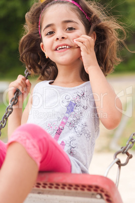 Lovely girl on a swing in the park