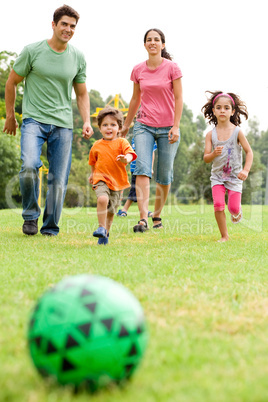 Family playing football in the park