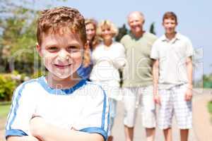 Young cute boy in focus with family in the background