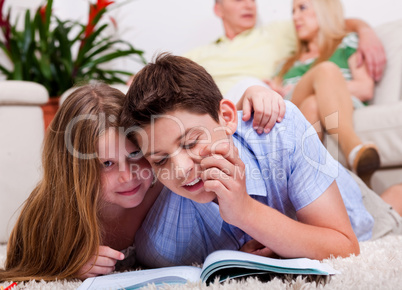 Kids studying with family in the background