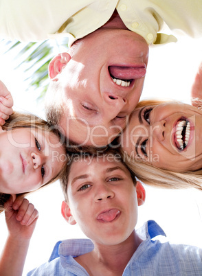 Joyful family making weird faces in huddle