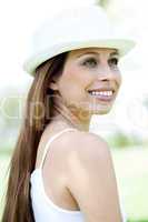 Happy young woman in hat looking away
