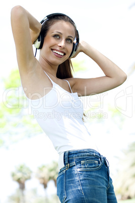 Happy young woman listening to music using headphones