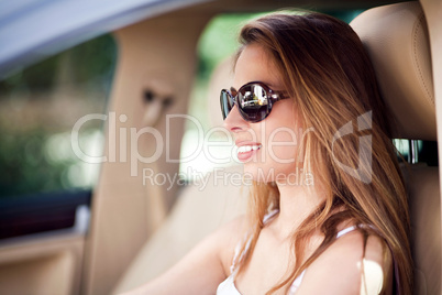 Beautiful woman driving car with sunglasses on