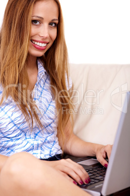 Beautiful young brunette using a laptop at home