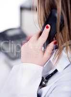 Back shot of a female doctor over a phone call