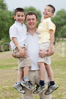Close up shot of curious father carrying his sons in his both hands