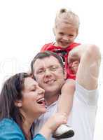 Happy couple with their beautiful daughter sitting on her father's shoulder