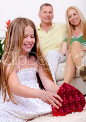 Happy young girl opening a gift box