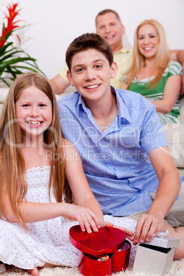 Happy young kids with gift boxes in living room