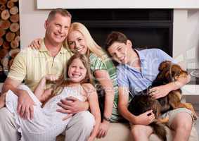 Happy domestic family sitting in living room with dog
