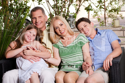 happy family sitting in patio and looking at you