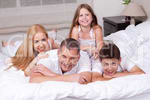 Happy family having fun on the bed