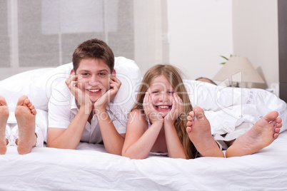 Loving Brother and sister lying and having fun on the bed