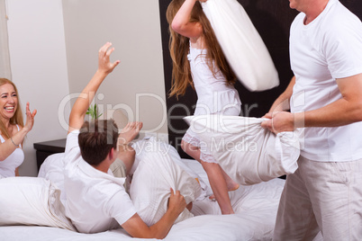 Lovely family having fun on their bed in living room