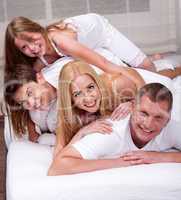 Cheerful family having fun together lying on a bed