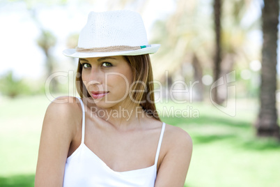 Smiling young woman posing with white hat