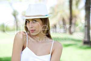 Smiling young woman posing with white hat