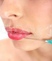 Doctor giving injection on face of a young woman on her upper lip