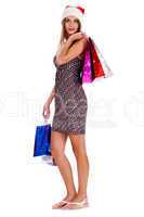 Full length of pretty woman holding colors shopping bags and wearing santa hat