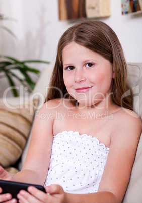 Young smiling girl looking at you in living room