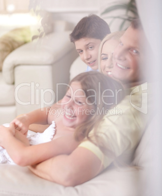 Happy family smiling and looking  behind the window glass