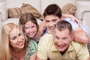 Smiling family lying together on the floor