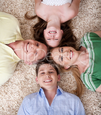 Happy family lying  with their heads close together smiling