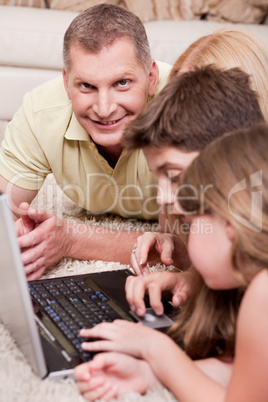 Happy family lying and working with lap top