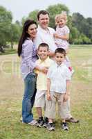 Happy family of five posing on natural background