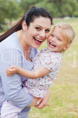 Curious mother carrying her daughter with big smile