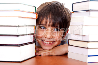 Young kid relaxing between pile of books