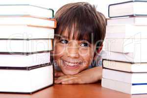 Young kid relaxing between pile of books