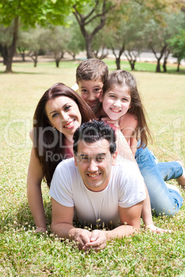 Happy family lying in the grass field at the park