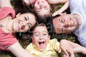 Parents and kids laying on the floor with heads together
