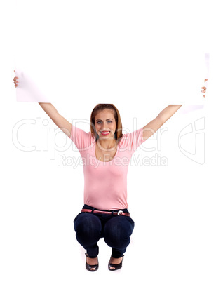 Smiling pretty woman with casual wear sitting and showing the white blank board